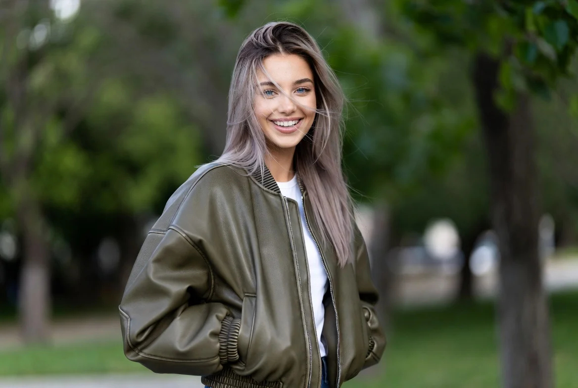 Young woman in leather jacket standing outdoors